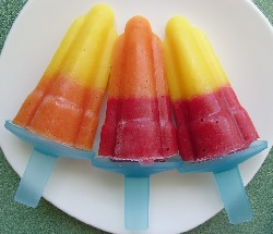 Three different coloured Tandem ice lollies on a plate.
