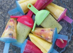 A selection of different coloured, shapes and sizes of fruit lollies in a large glass dish