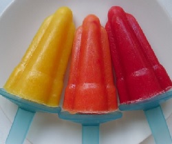 A yellow, orange and red ice lolly on a plate.